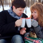 young beloved couple warming themselves in the winter park