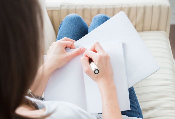 woman writing in journal keystone habits