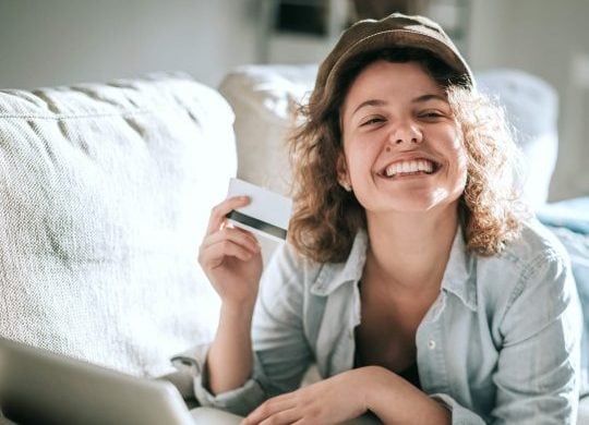 woman laying on sofa smiling posing Signs of a Confident Woman