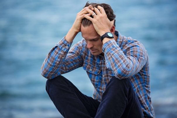 depressed man sitting on ground by lake, can a narcissist change