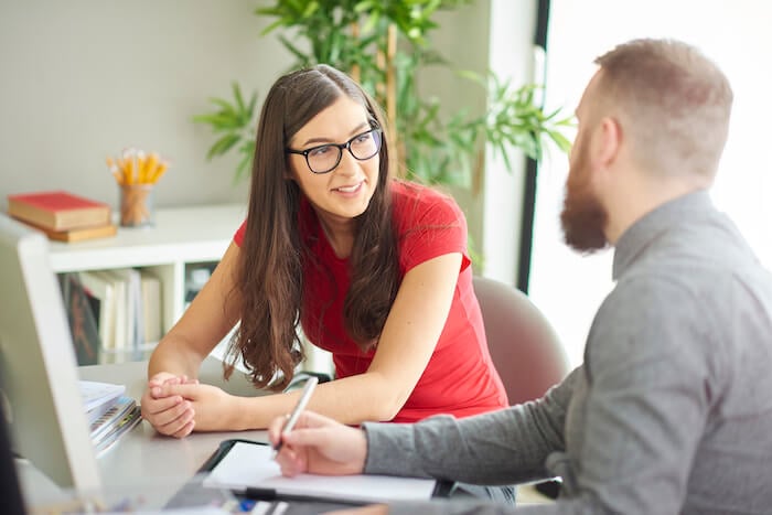 woman and man talking at desk how to end a conversation