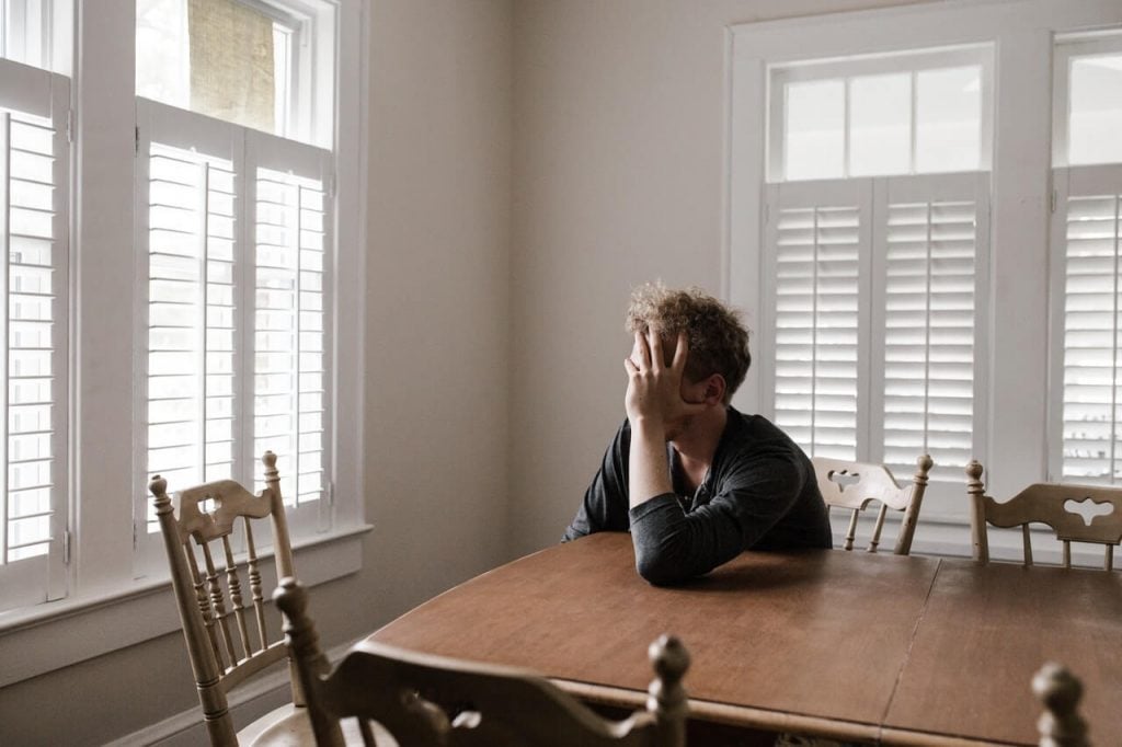 man sad at table get out of your head