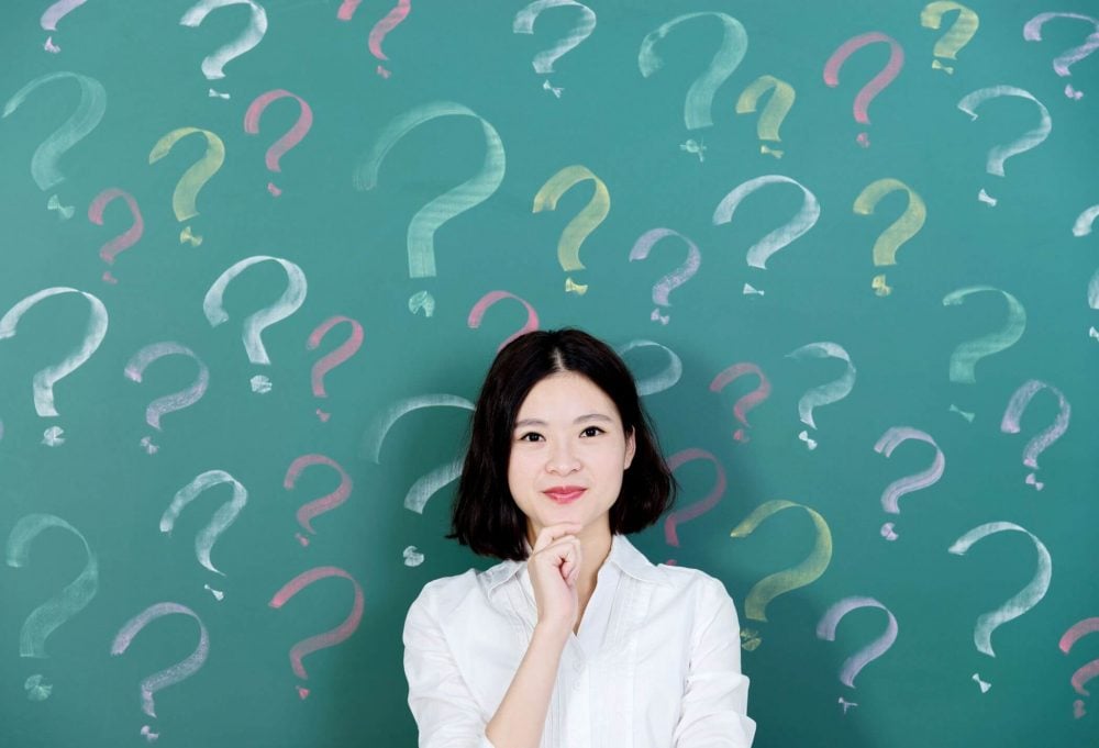 woman standing with question marks on board yes or no questions