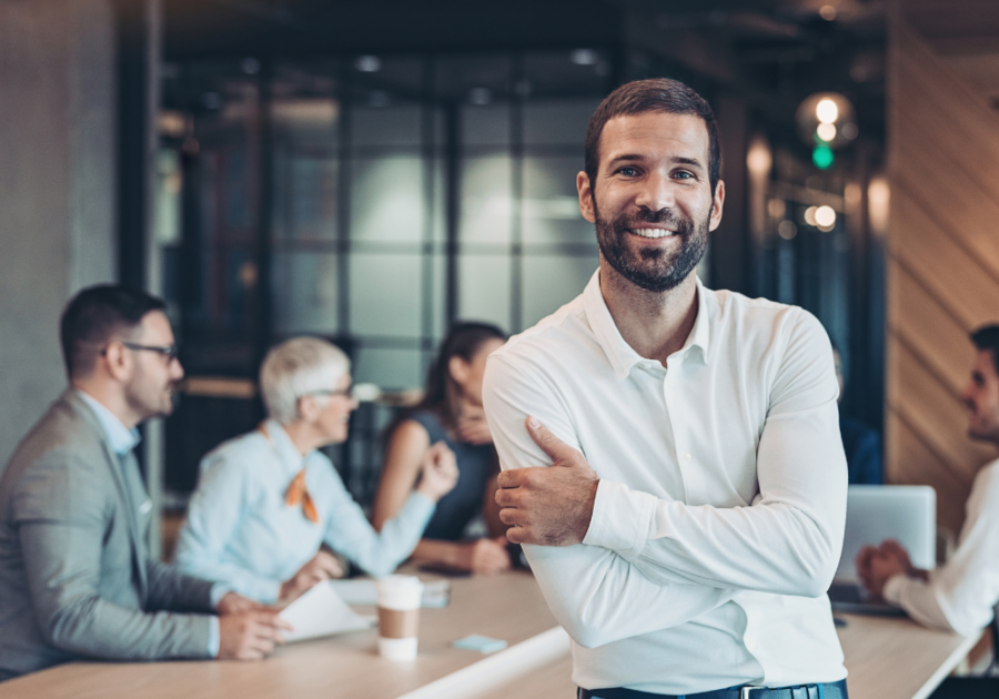 man in corporate room smiling How to be a Sigma Male