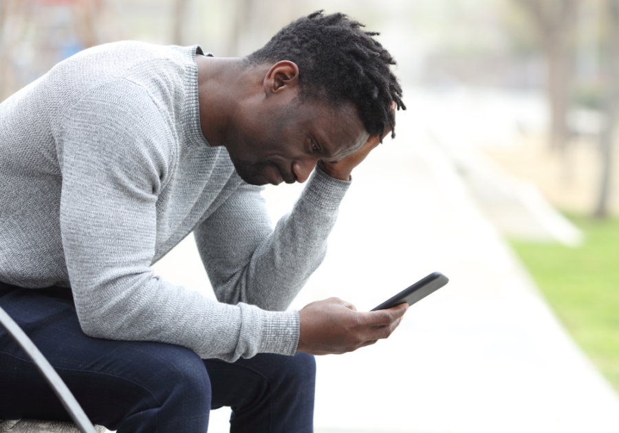 Man looking at phone outside is it ok to break up over text