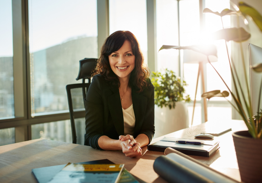 lady boss smiling at the camera signs your boss likes you but is hiding it 