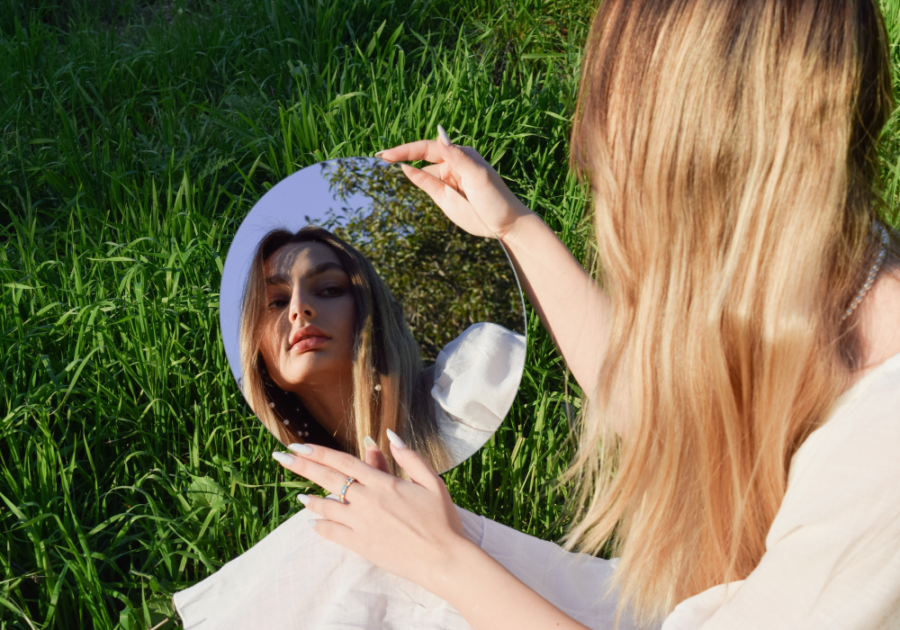 woman looking at her reflection in the mirror signs of a heyoka empath