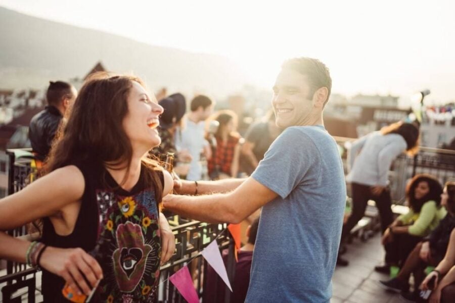 man and woman laughing and talking at concert signs he likes you but is afraid of rejection