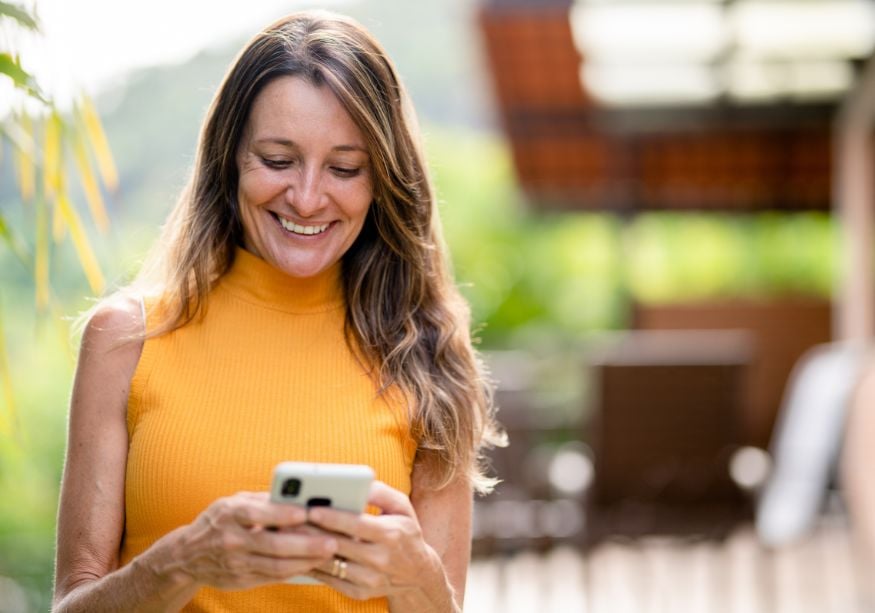 woman smiling looking at phone Good Morning Paragraphs for Her to Make Her Smile