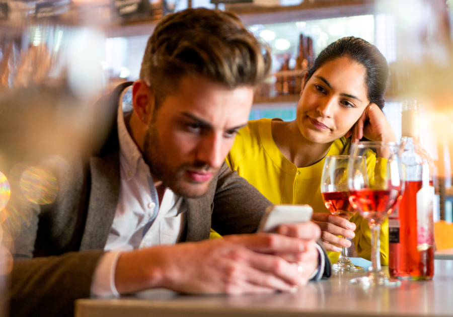 woman watching man at bar on phone toxic personality traits