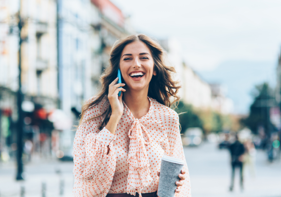 woman on phone laughing Funny Responses When Someone Asks, "How Are You?"