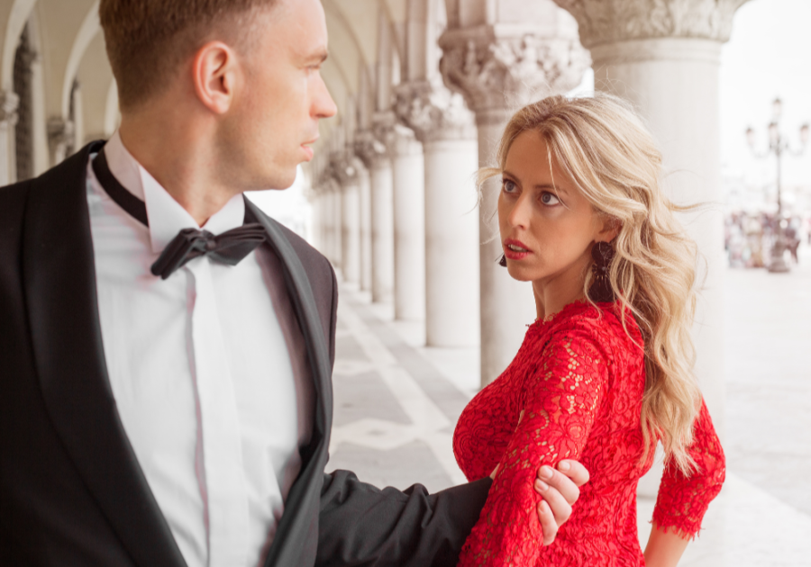 couple dressed formal man holding woman's arm Early Signs of a Possessive Man