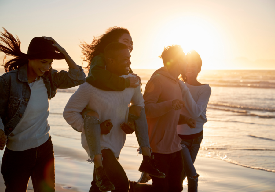 couples laughing on beach Polyamory vs. Open Relationship