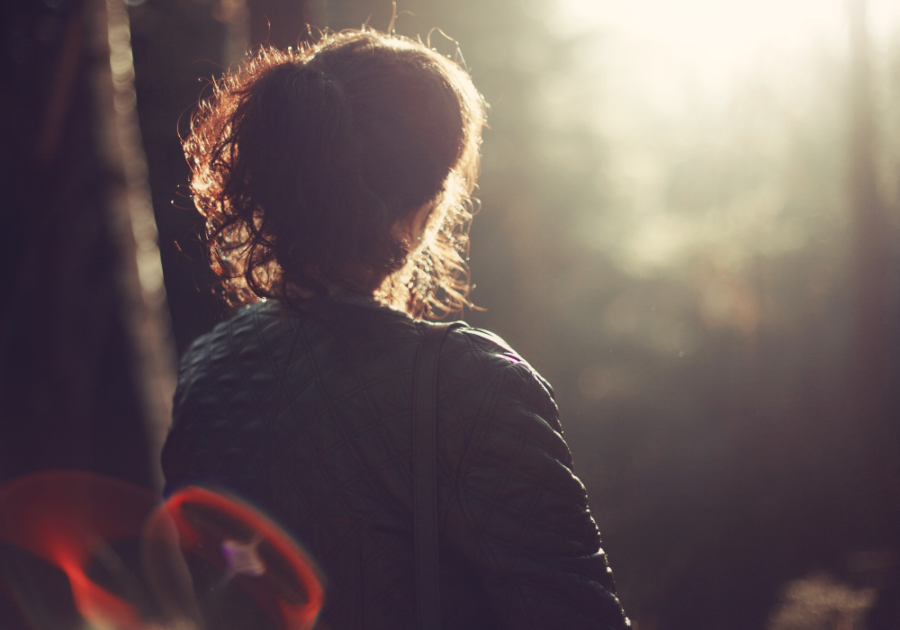 woman sittiing in dark looking at light dark feminine energy