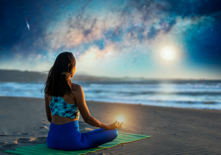 woman sitting on beach at sunset dark feminine energy