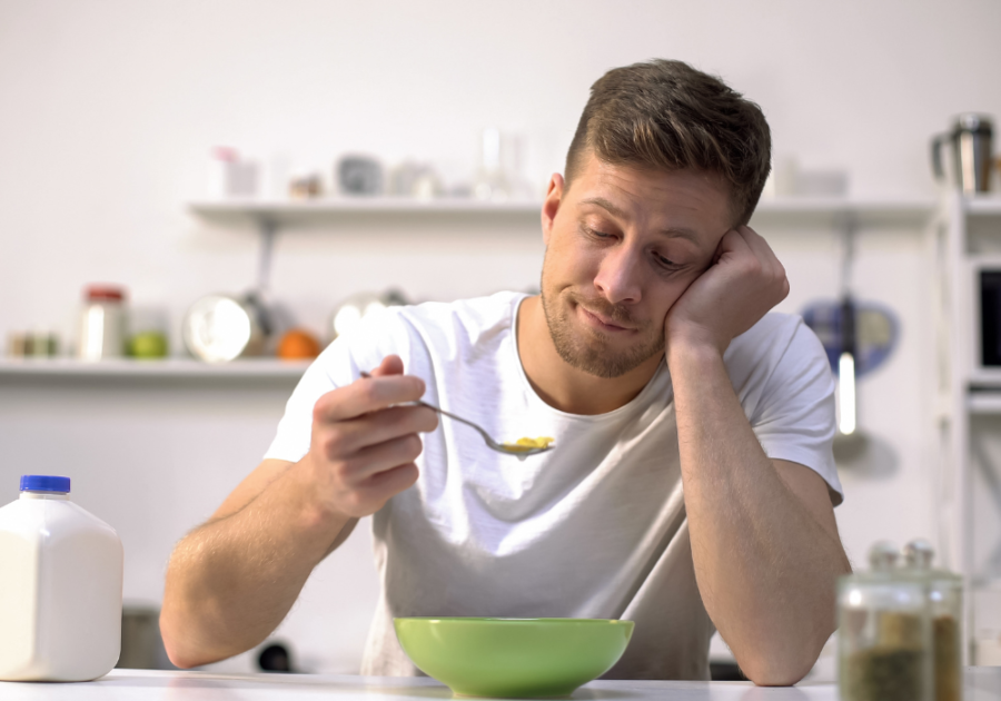 man eating at table tired and sad Psychological Effects of Being Single Too Long