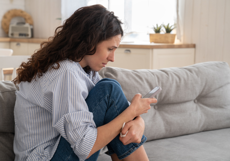 Woman sitting on sofa and looking at phone