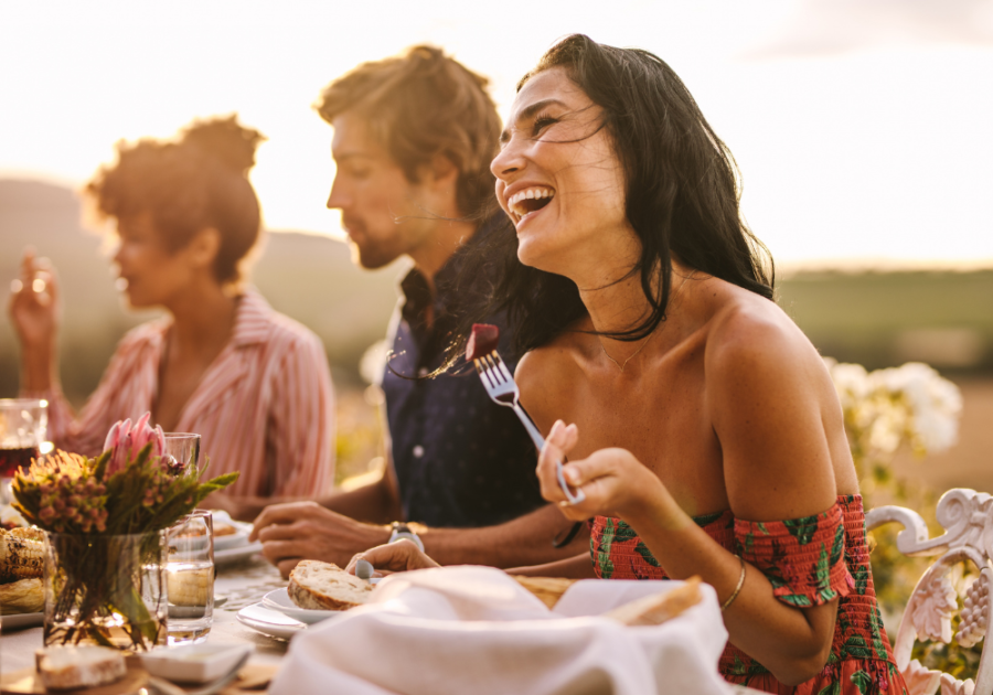 group sitting down for dinner outdoors Stop Wanting a Relationship So Badly