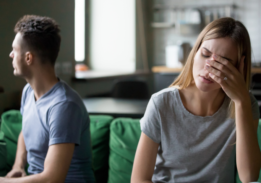 couple sad sitting on sofa turned of by husband