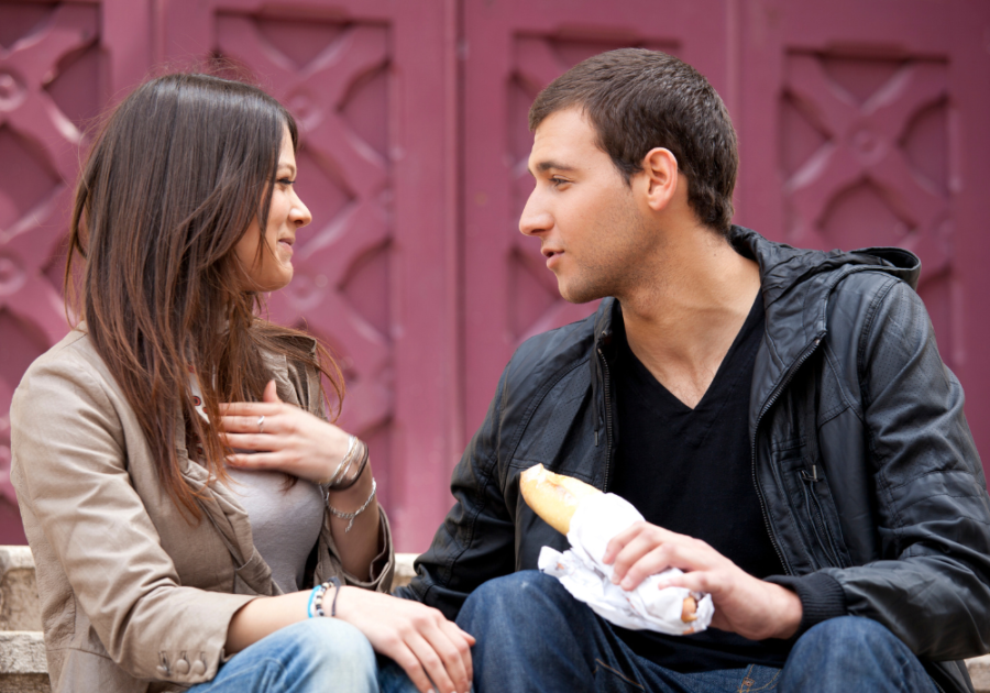 couple sitting outdoors talking Keep a Conversation Going with a Girl