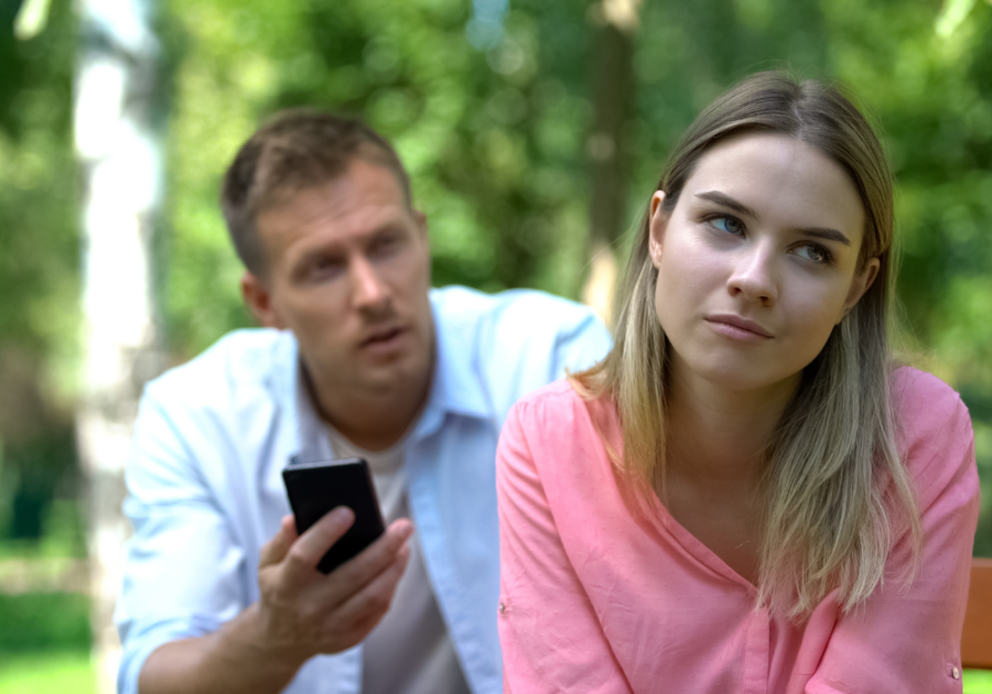 couple outdoors man frustrated looking at phone Hysterical Bonding