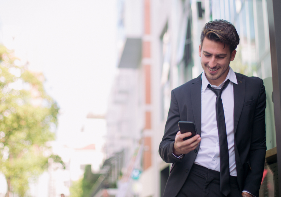 man in dress suit looking at phone Make Him Miss You