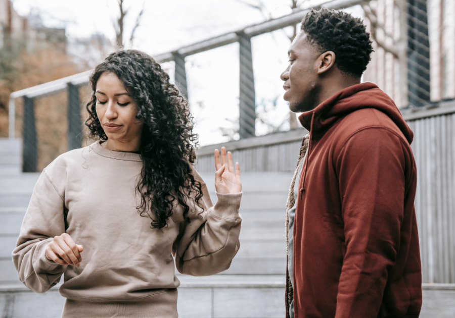 woman holds hand up to man to stop Things Your Partner Should Never Say to You