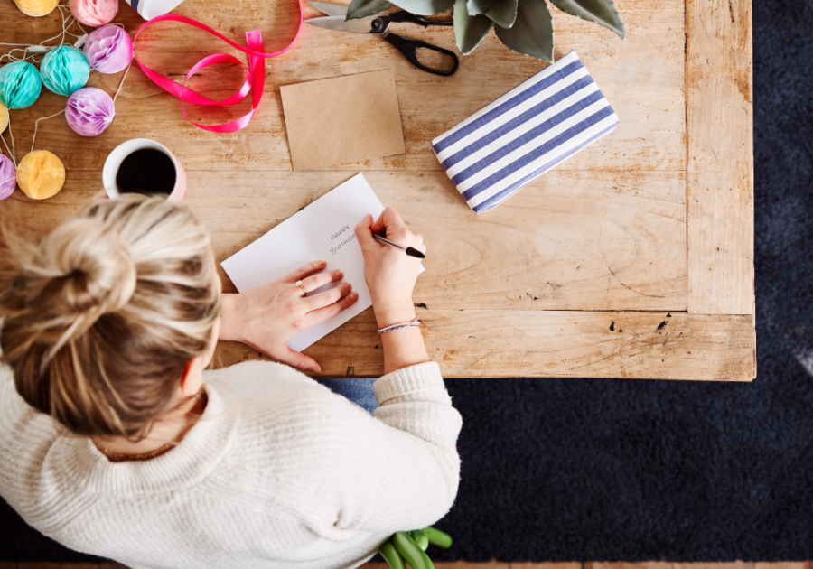 woman sitting at desk writing a card Birthday Paragraphs for Your Best Friend