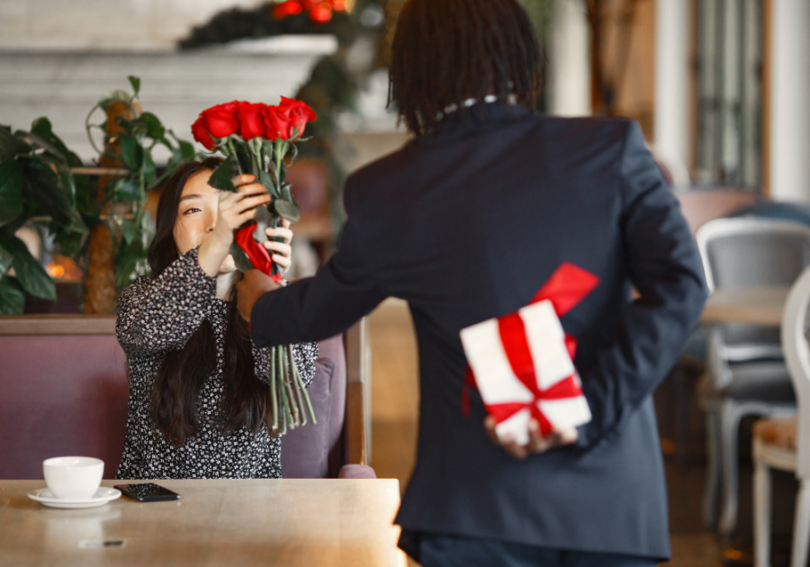 man at table giving woman gifts Court a Woman