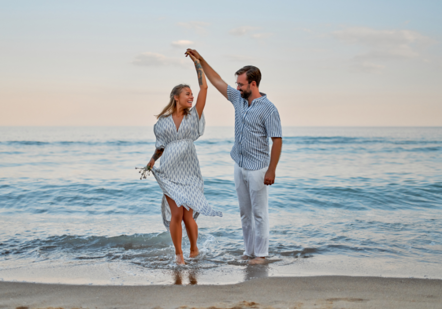 couple dancing along ocean front Court a Woman