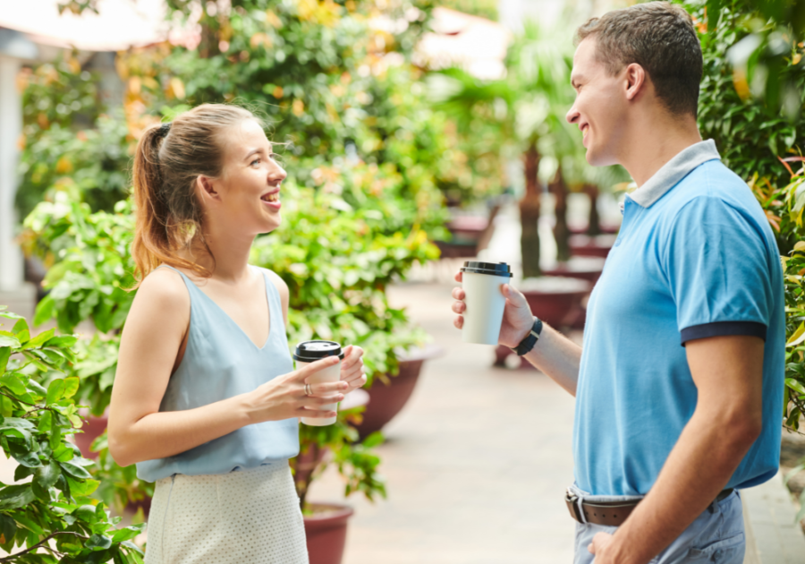 woman smiling at man outdoors how to tell if a guy is interested in your or just being friendly