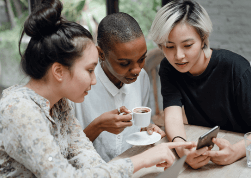 three women looking at phone orange personality type